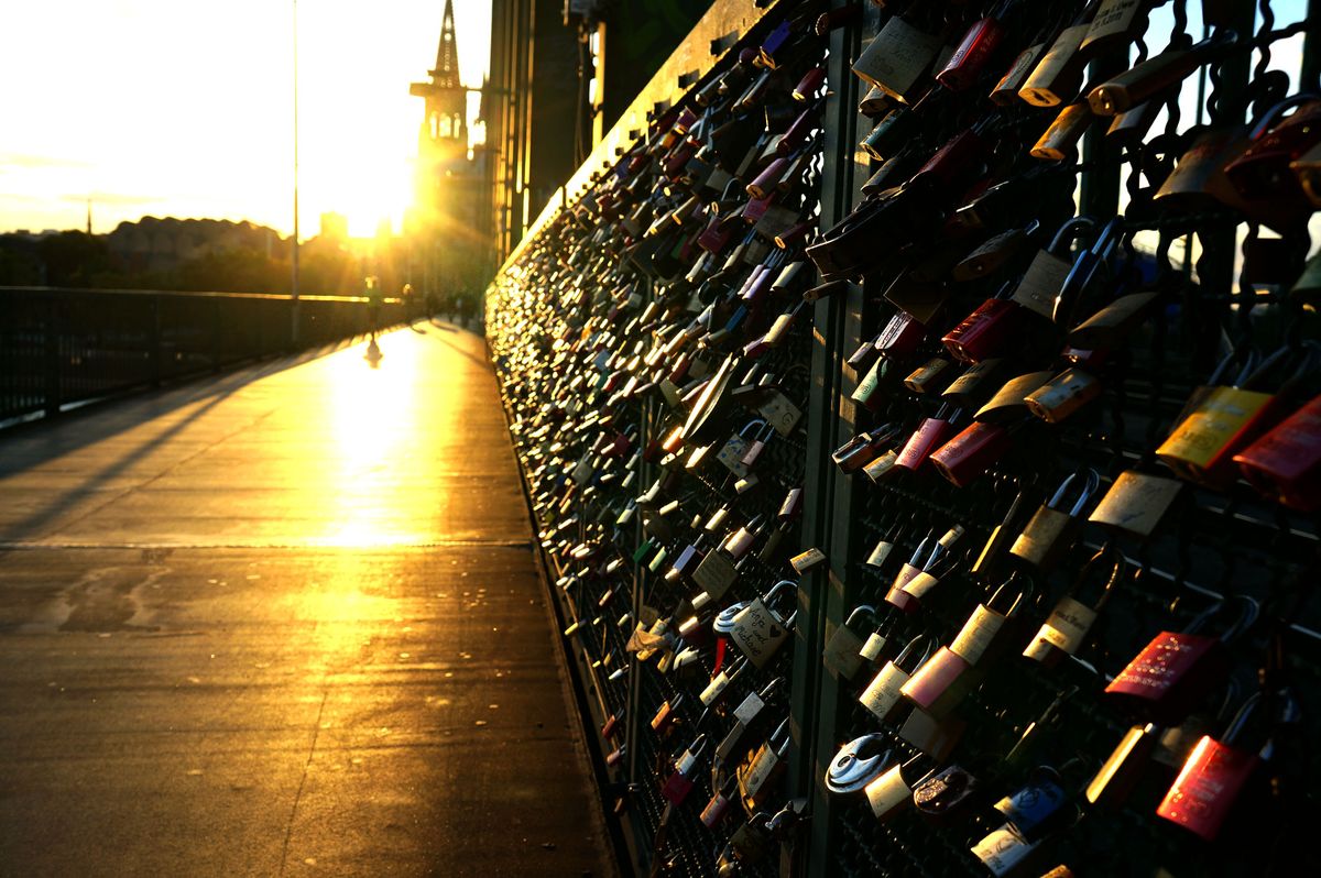 The locks that lovers and loners leave, attached to bridges, illuminated by the setting summer sun.